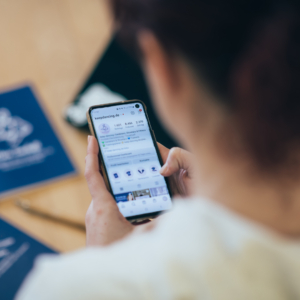 Trainerin hält Handy mit Instagram in der Hand